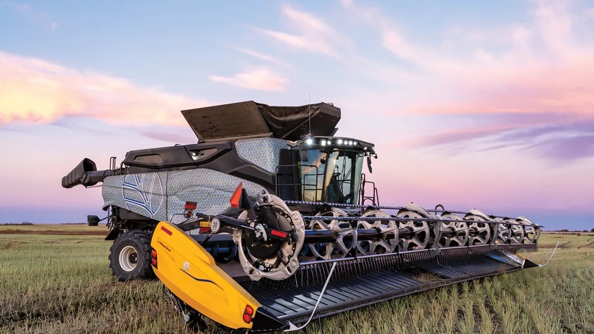 A combine harvester is seen in a farm field