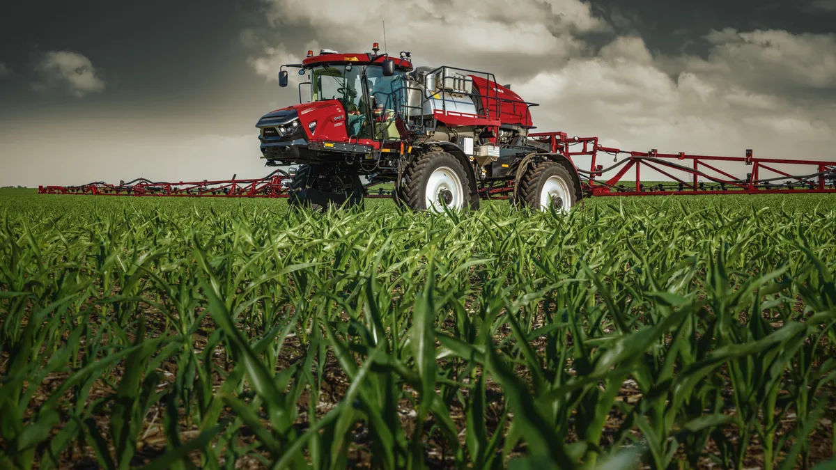 A sprayer is seen in a corn field