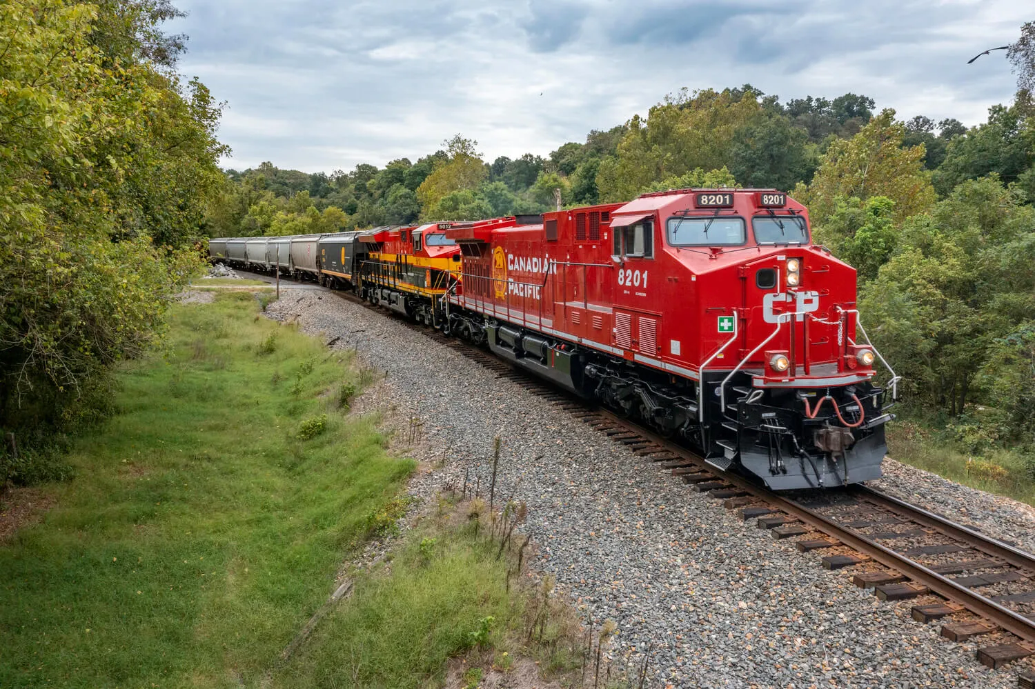 A red train displaying the Canadian Pacific logo moves along a track.