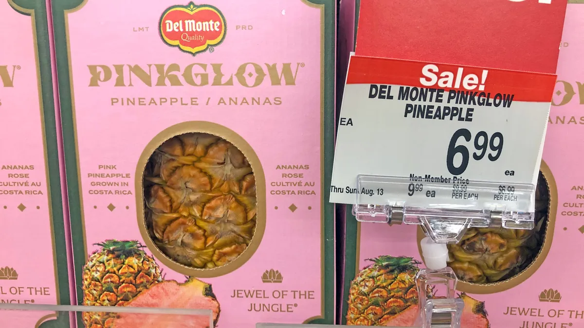 Pinkglow pineapples are seen on a grocery store shelf.