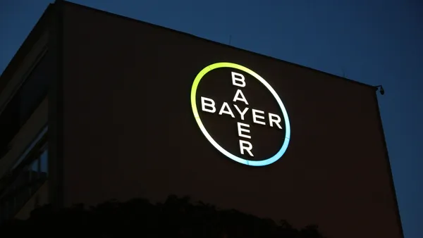 The Bayer logo is seen lit up at night on the side of a building