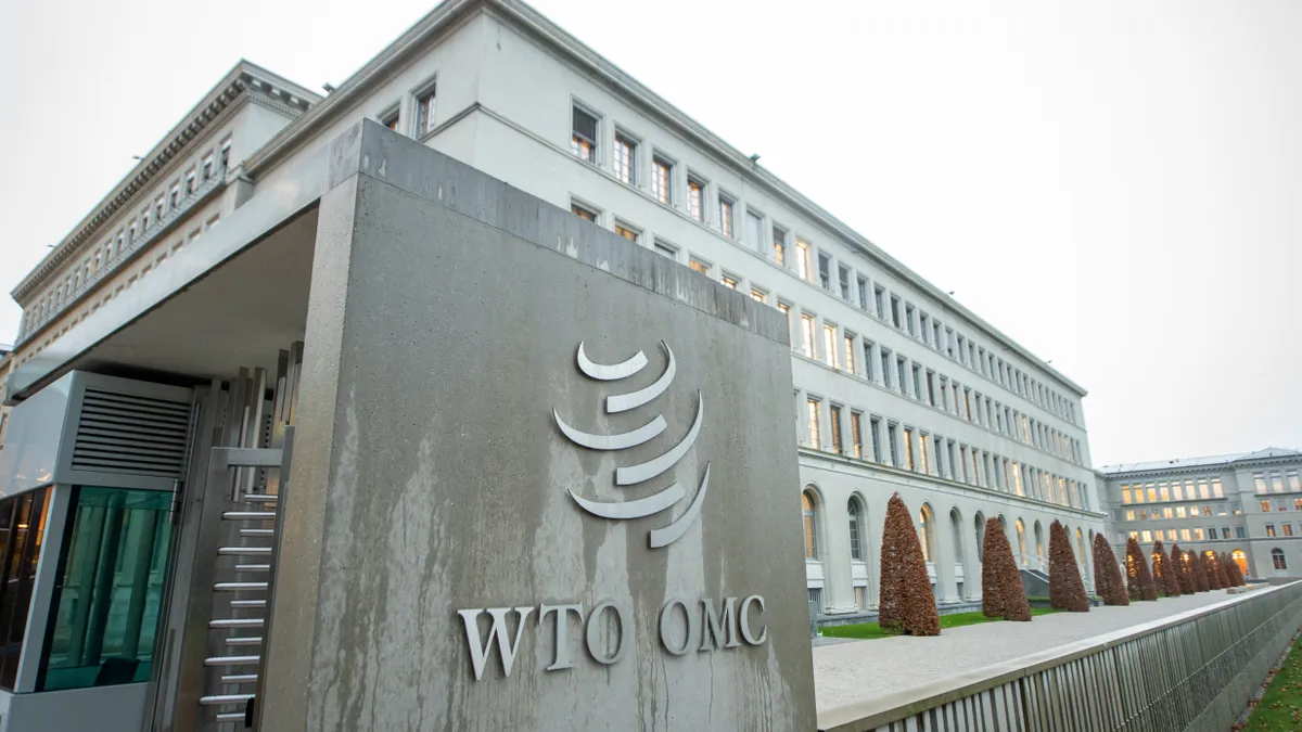 A building is seen with a sign that says "WTO OMC" in front.