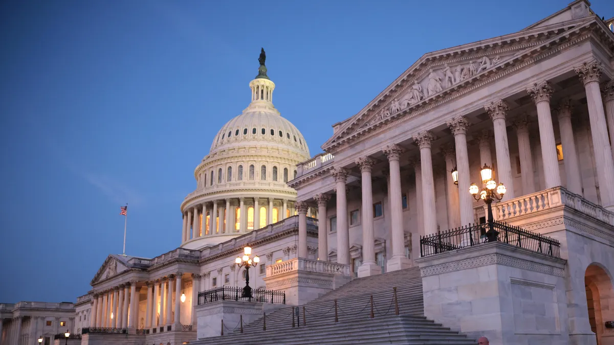 A man exits the front of the U.S. Capitol at dawn.