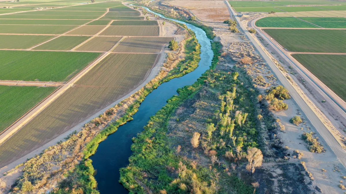 An aerial view of the Colorado River is seen. Surrounding the river is farmland