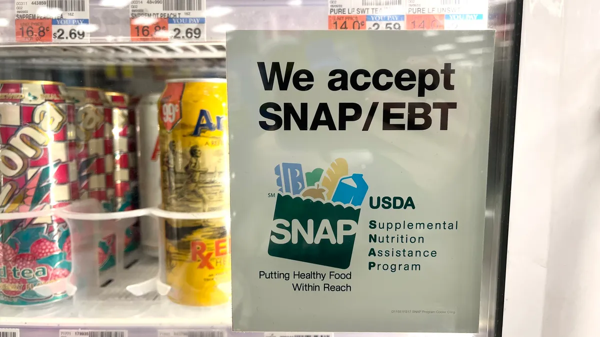 A sign on a drinks case door that reads "We accept SNAP/EBT."