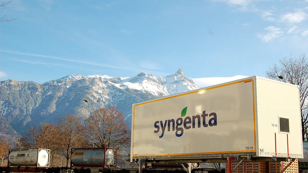 A trailer with the Syngenta logo sits at the base of mountains in Switzerland